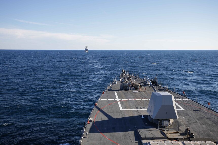 The Ticonderoga-class guided missile cruiser USS Normandy (CG-60) steams ahead of the Arleigh Burke-class guided-missile destroyer USS Truxtun (DDG 103) during maneuvers at sea
