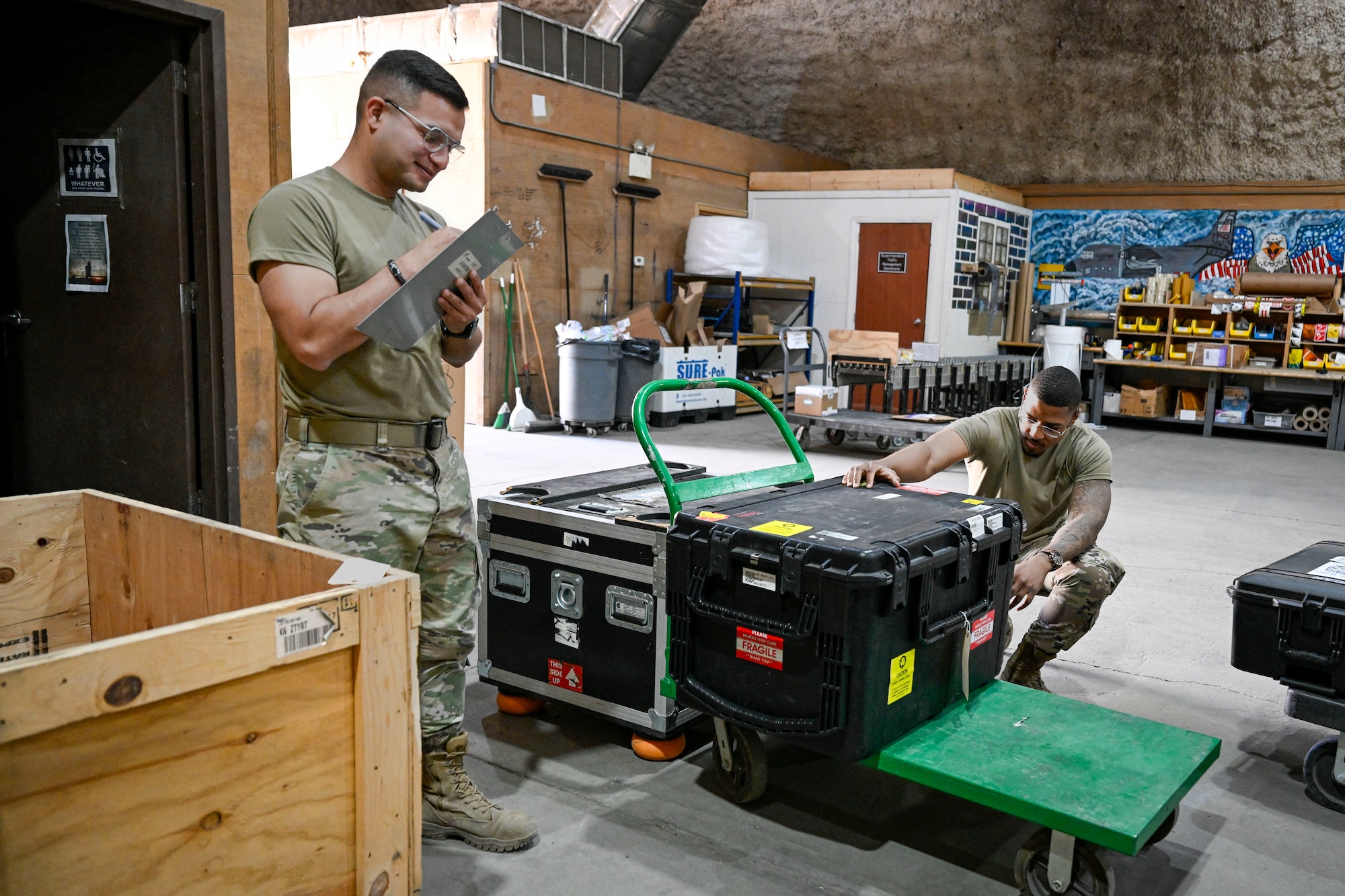 Two U.S. Air Force Airmen conduct inventory inside.