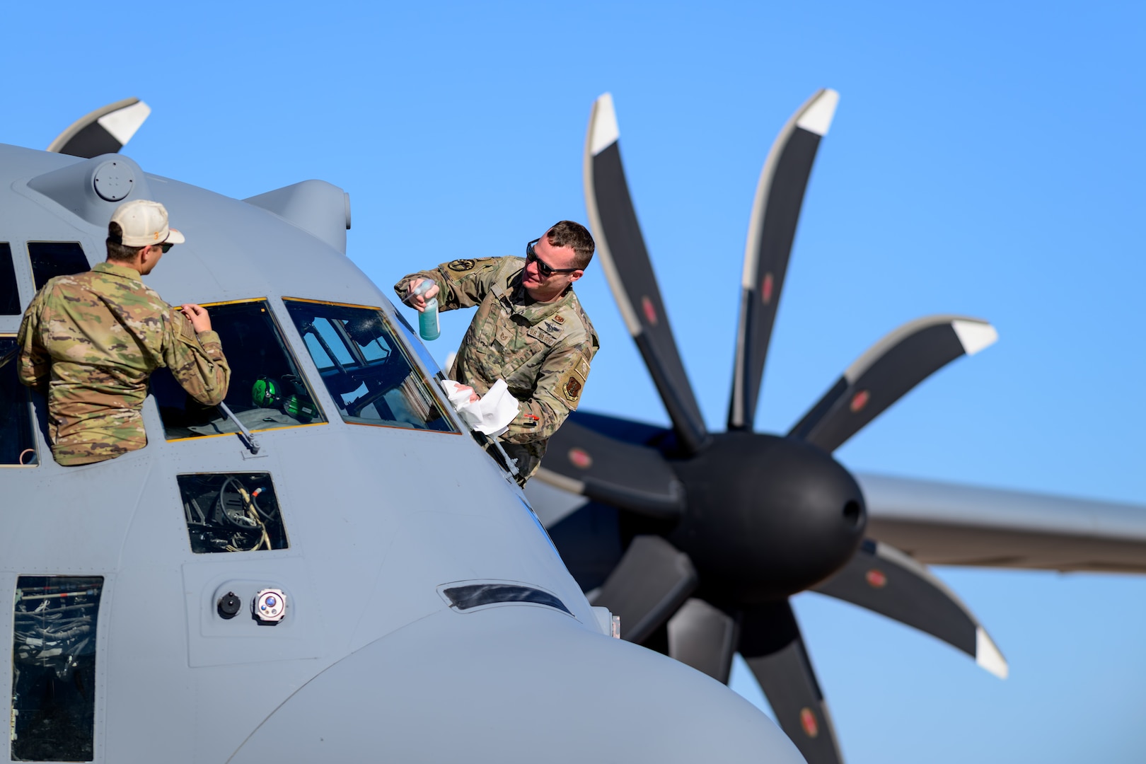 Airmen assigned to the Wyoming Air National Guard’s 153rd Airlift Wing clean the windshield of a C-130 Hercules aircraft during Modular Airborne Firefighting System training at Fort Huachuca, Arizona, Feb. 13, 2025. The training prepares aircrews for the upcoming fire season.