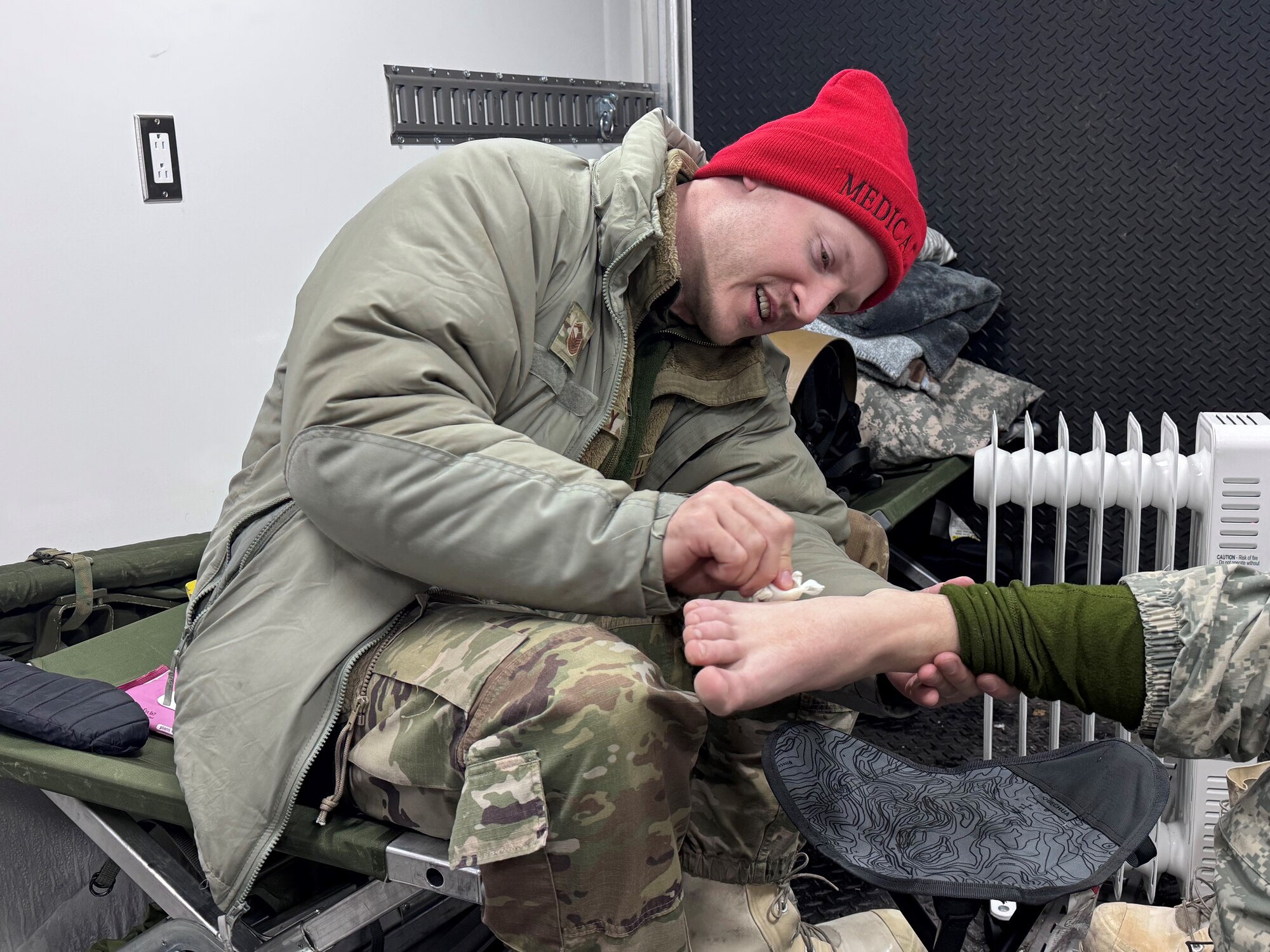 Master Sgt. Sean Prouty, an aerospace medical specialist assigned to the 148th Fighter Wing, Minnesota Air National Guard, applies first aid to a service member during the Air National Guard’s Cold Weather Operations Course at Camp Ripley Training Center, Minn., Feb. 6, 2025.  The course, attended by 70 students from 37 Air National Guard wings, was planned, and hosted by the Minnesota National Guard’s 148th Fighter Wing. The course was designed to prepare service members for deployments to cold weather regions and assist in planning missions with the goal of mitigating cold weather injuries. (U.S. Air National Guard photo by Audra Flanagan)