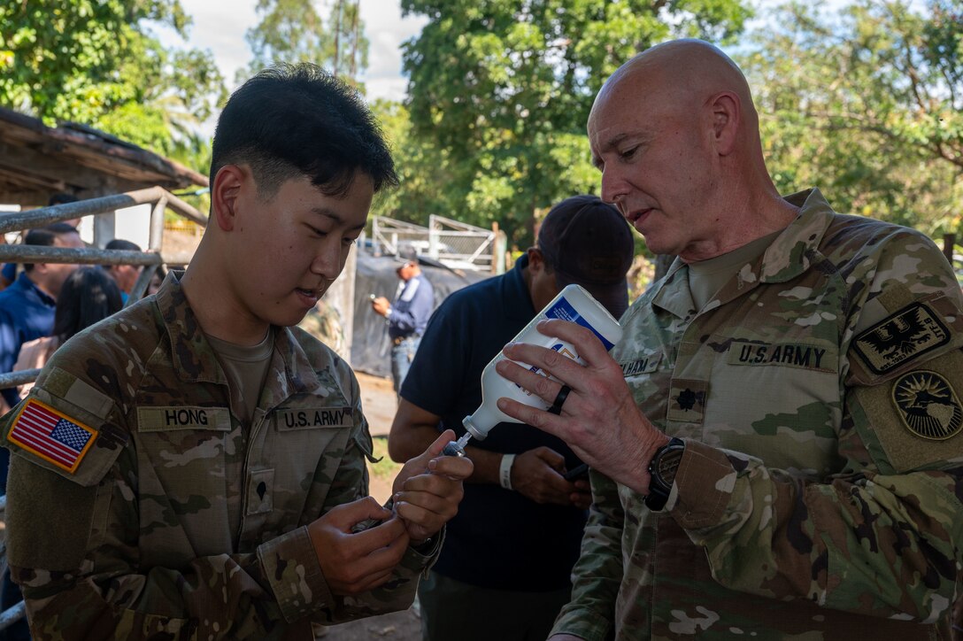 U.S. Army Lt. Col. Steven Pelham assists Spc. Sunwook Hong with drawing a dose of ivermectin to be used to deworm livestock near Ahuachapan, El Salvador, Feb. 19. This initiative aims to curb the spread of vector-borne illnesses that threaten animal and human populations. (U.S. Air Force photo)