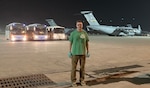 Man standing on airfield at night.