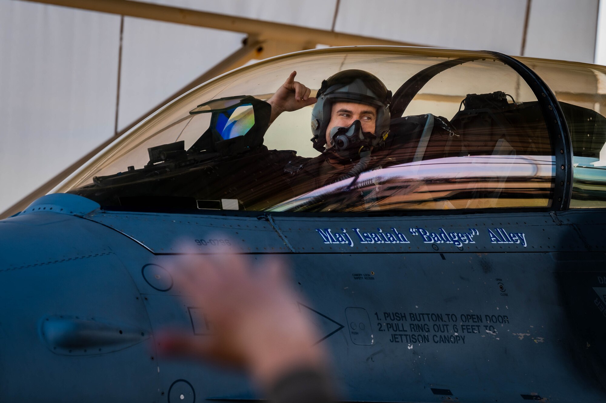 U.S. Air Force Maj. Isaiah Alley, 309th Fighter Squadron director of operations, signals goodbye to his loved ones as he taxis a U.S. Air Force F-16 Fighting Falcon.