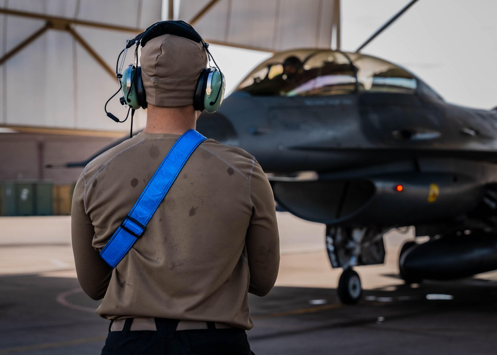 U.S. Air Force Senior Airman Emanuel Jones, 309th Aircraft Maintenance Unit F-16 Fighting Falcon crew chief, prepares to guide U.S. Air Force Maj. Isaiah Alley, 309th Fighter Squadron director of operations, onto the taxiway.