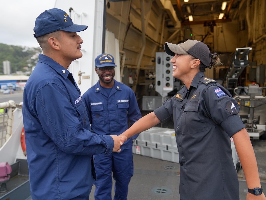 Petty Officer 3rd Class Raymond Vasquez-Carranza, a storekeeper aboard the Coast Guard Cutter Midgett (WMSL 757) and Royal New Zealand Navy Able Writer Jordi Kotuhi-Brown shake hands as Brown departs the Midgett after sailing onboard, in Wellington, New Zealand Feb. 10, 2025. The United States and New Zealand maintain close cooperation in supporting a Pacific islands region that is peaceful, secure, prosperous, and resilient. (U.S. Coast Guard photo by Petty Officer 3rd Class Jennifer Nilson)