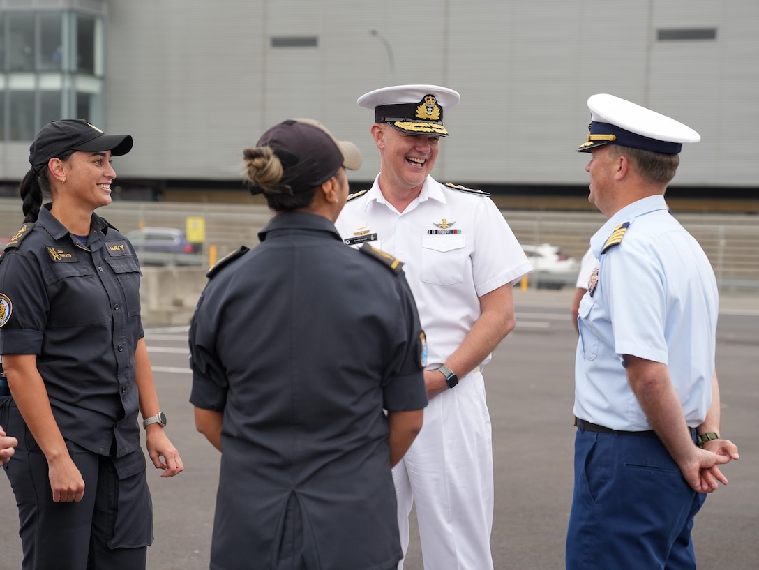 Coast Guard Capt. Matthew Rooney, the commanding officer of the Coast Guard Cutter Midgett (WMSL 757) laughs with Deputy Chief of Navy, Commodore Quentin Randall, of the Royal New Zealand Navy, Leading Communications Warfare Specialist Jade Taikato and Able Writer Jordi Kotuhi-Brown, in Wellington, New Zealand Feb. 10, 2025. The Coast Guard supports New Zealand’s efforts to build resilience and strengthen maritime security. (U.S. Coast Guard photo by Petty Officer 3rd Class Jennifer Nilson)