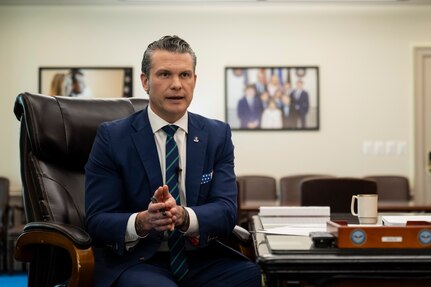 Defense Secretary Pete Hegseth delivers remarks while seated in an office.