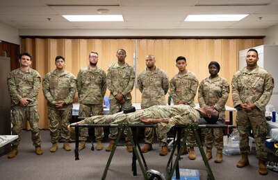 U.S. Army Soldiers (from left) Staff Sgt. Derek J. Born, Spec. Adrian E. Comas-Perez; Spec. Zachary S. Juengel; Spec. Christen O. Johnson; Spec. Kelvin Weiner Jr.; Spec. Maxwell H. Ghimire; Pfc. Mary Amponsah; and Sgt. 1st Class Anthonytomas P. Ortiz, pose for a photo after completing hands-on training in Medial Competency Assessment Program at Tripler Army Medical Center on Nov. 1, 2024. Born and Ortiz are instructors assigned to TAMC, and the remaining soldiers are students assigned to the 25th Infantry Division at Schofield Barracks.