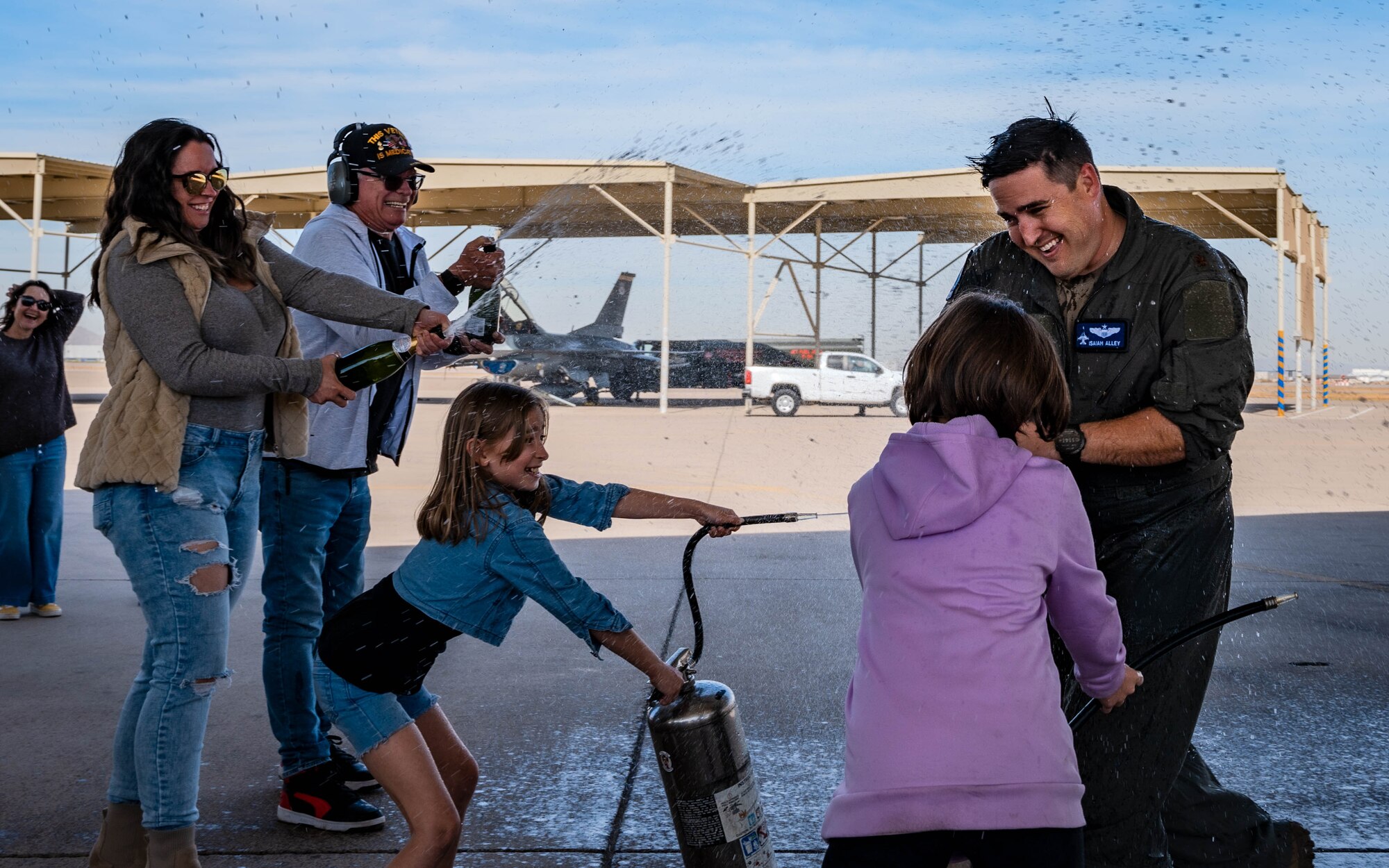 U.S. Air Force Maj. Isaiah Alley, 309th Fighter Squadron director of operations, is sprayed with water and champagne by his wife, daughter, and other family members following his final active-duty flight.
