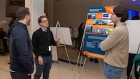 Attendees explore exhibits during a poster session and open house of an enterprise-wide event themed “Design Your Future,” held at Naval Surface Warfare Center, Carderock Division to commemorate Engineers Week, Feb. 18, 2025.