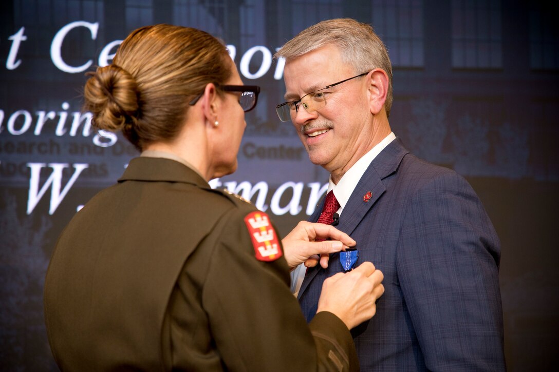 Maj. Gen. Kimberly Colloton, deputy commanding general of the U.S. Army Corps of Engineers, presents Dr. David W. Pittman, Senior Executive Service (SES), with the Distinguished Civilian Service Medal during his retirement ceremony at ERDC. The award, the highest honorary recognition for Army civilian personnel, honors Pittman’s 38 years of service and leadership.