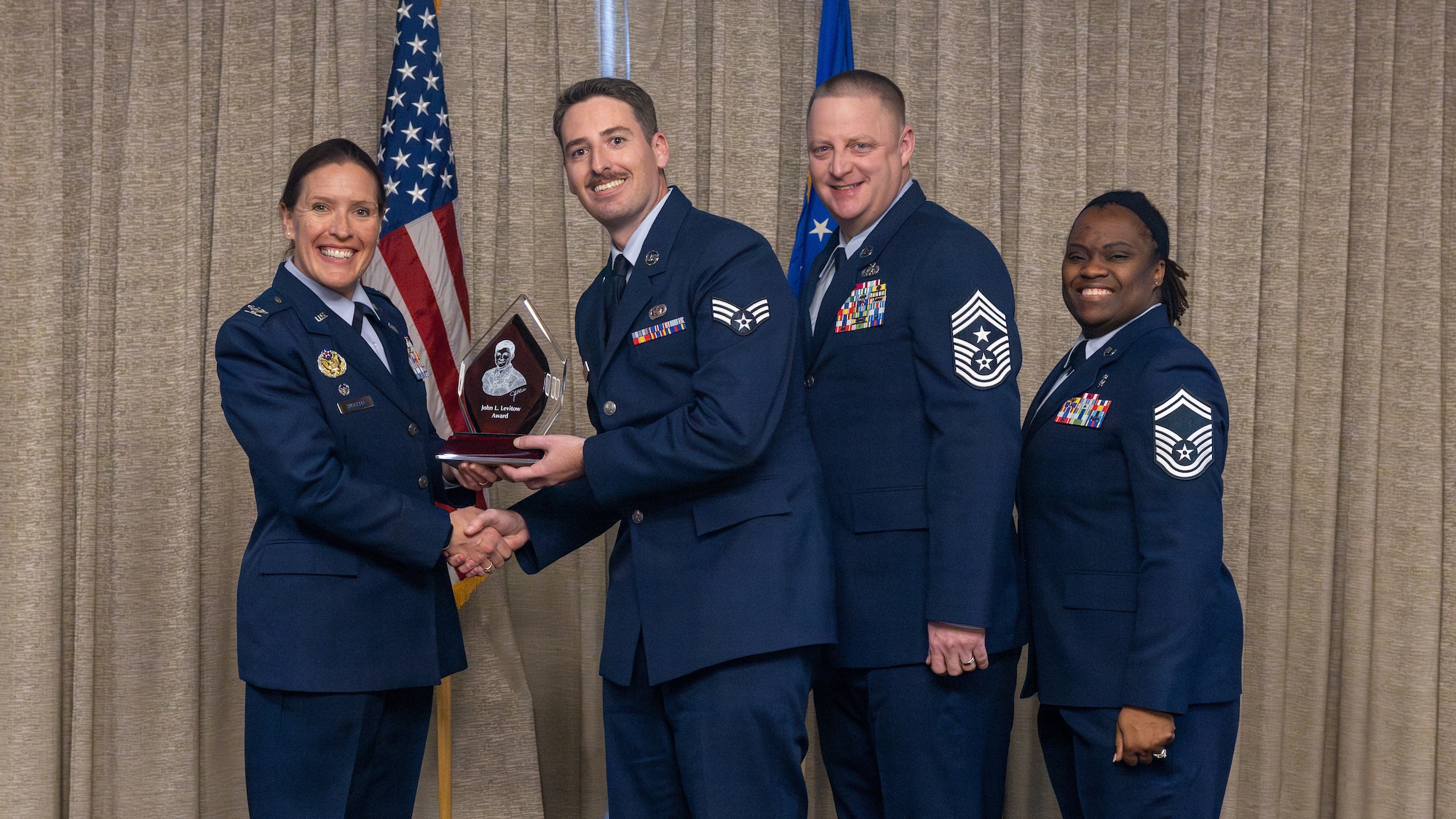 airman accepts award surrounded by friends and family