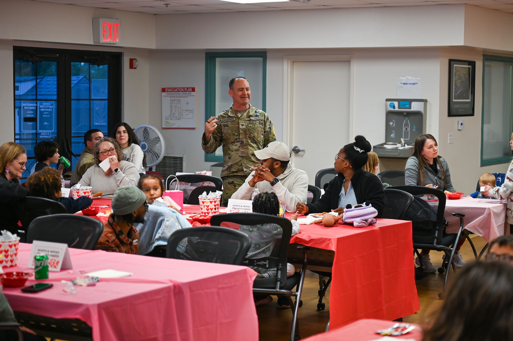 Col. Mark Shoemaker speaks in a room full of people.