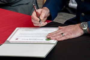 A person signs a piece of paper