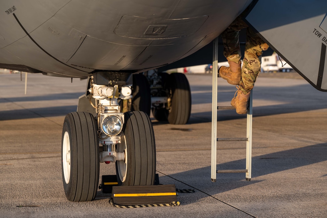 Photo of Airman climbing ladder to maintain a C-17.