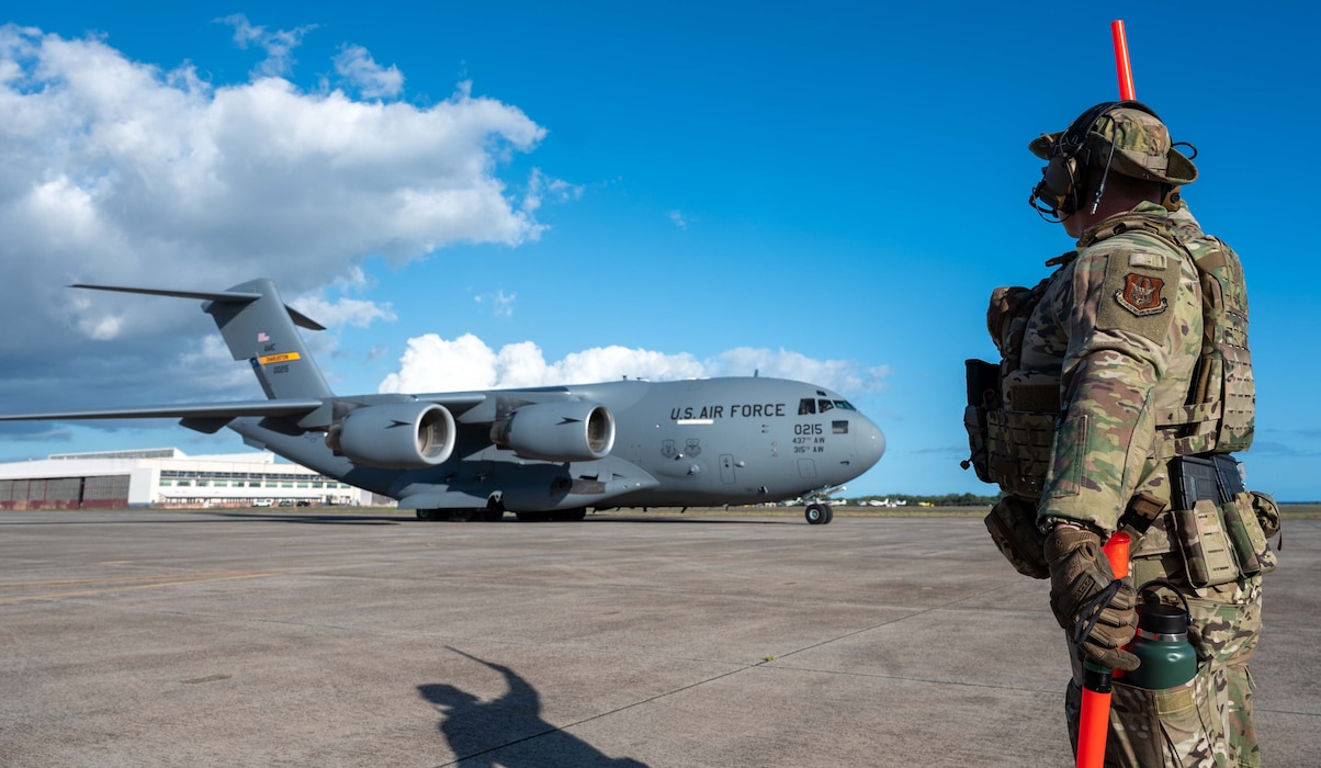 Photo of an Airman marshalling a C-17