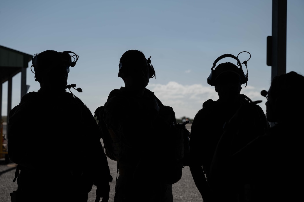 Photo of three Airmen discussing flight operations