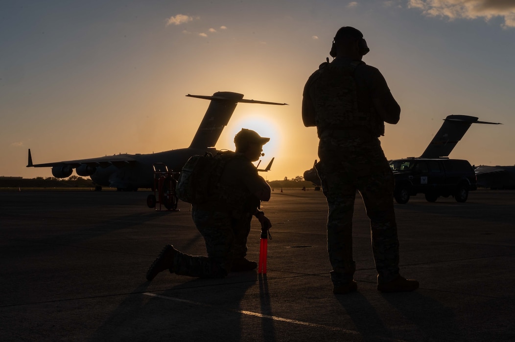 Photo of two Airmen waiting on an aircraft