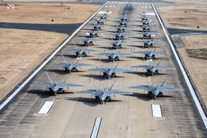 A large group of military aircraft line up on a flight line.