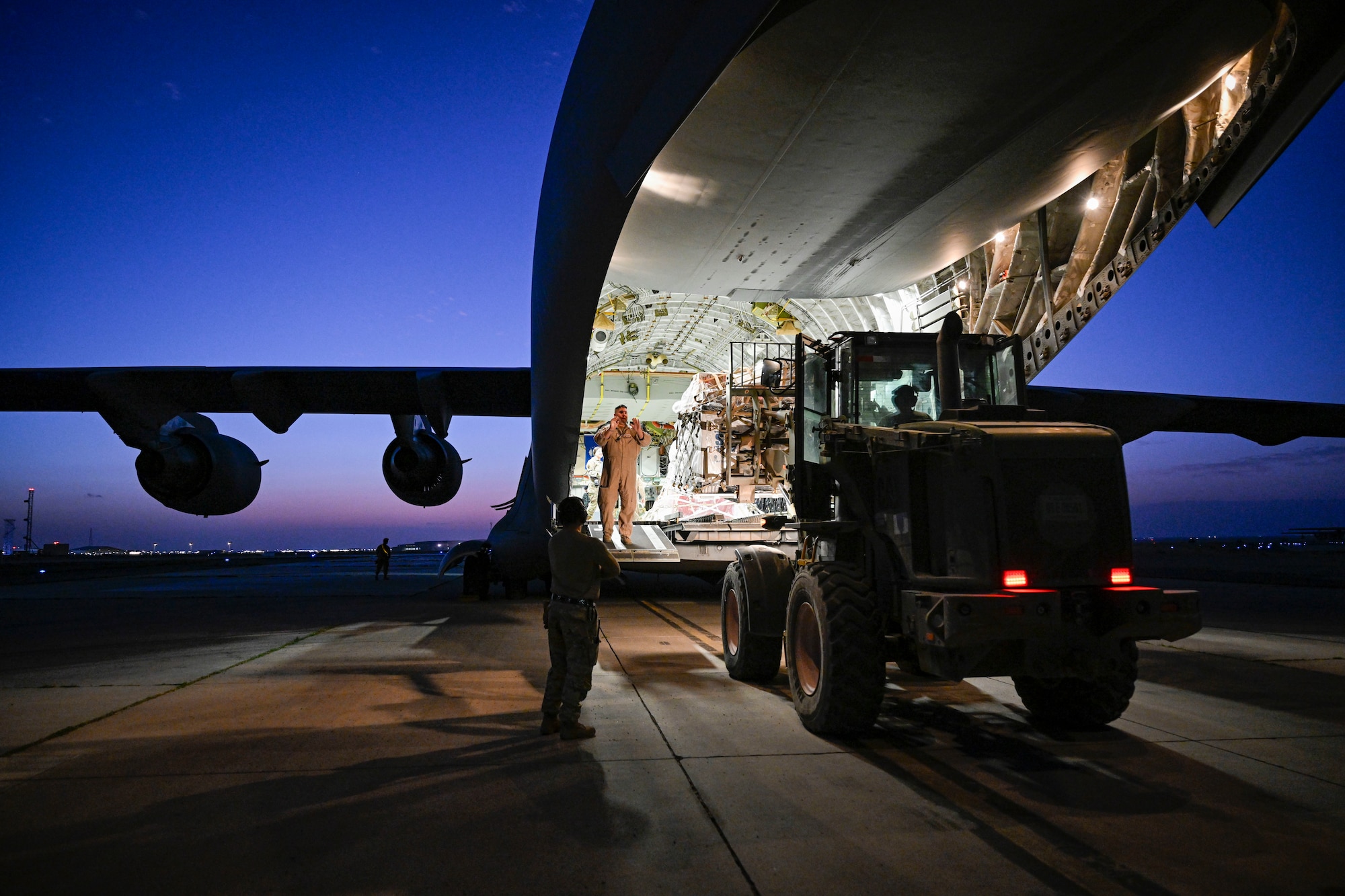 A forklift approaches the back of an aircraft.
