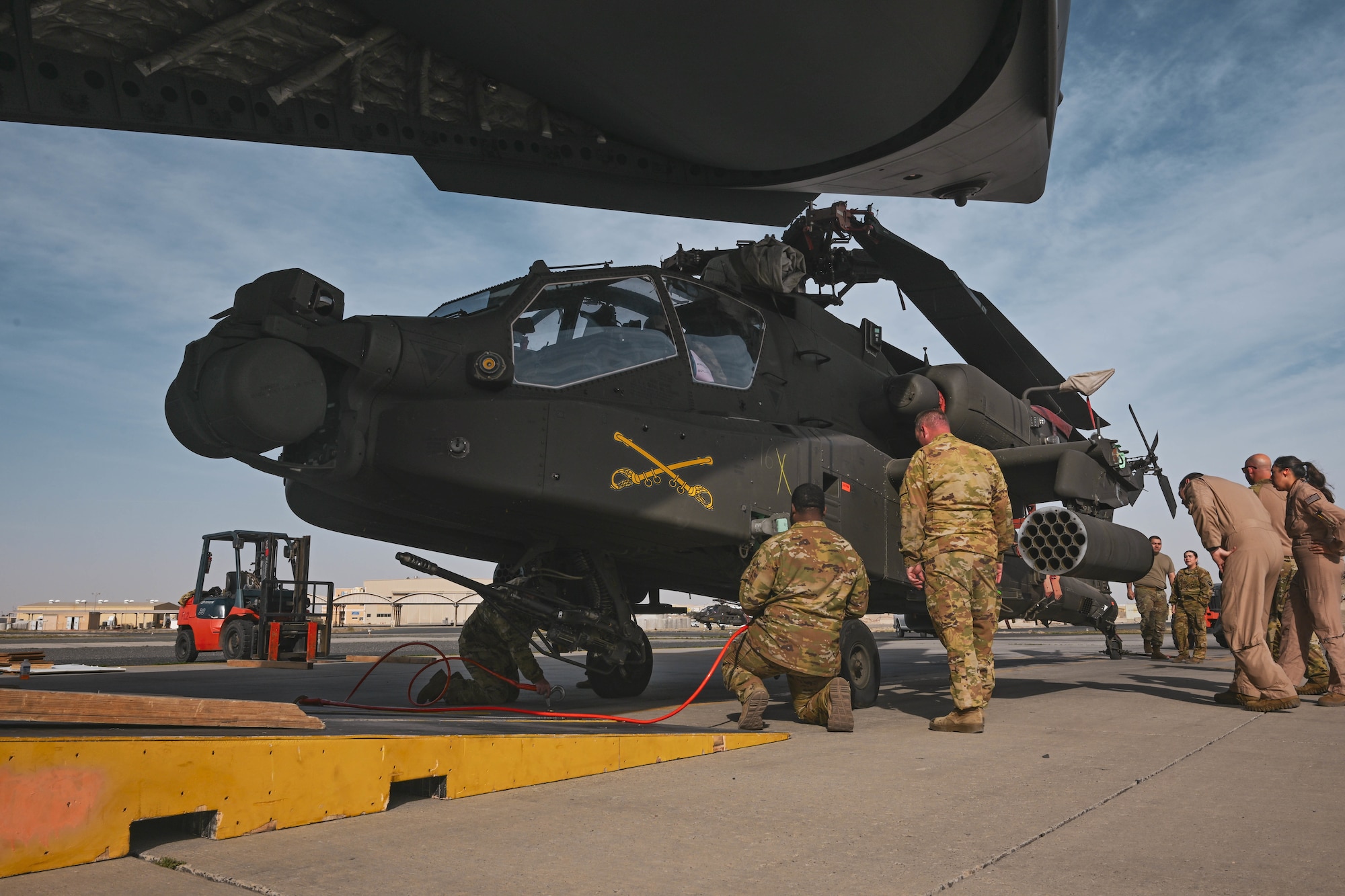 People in uniform stand around a helicopter.