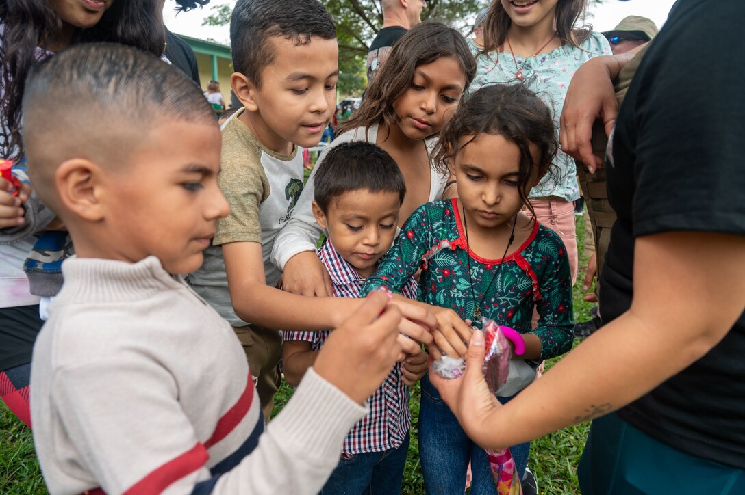 Children from El Llano de la Puerta, Comayagua, Honduras, receive candy from a Joint Task Force-Bravo member during the 100th Chapel Hike Feb. 22. The Chapel Hike, a volunteer program, has become synonymous with JTF-Bravo's commitment to the Honduran people. (U.S. Air Force photo by Capt. Hillary Gibson)