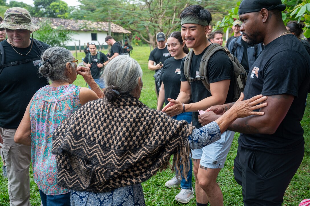 A woman thanks JTF-Bravo members after receiving her food donation during Joint Task Force-Bravo’s 100th Chapel Hike Feb. 22. The Chapel Hike, a volunteer program, has become synonymous with JTF-Bravo's commitment to the Honduran people. (U.S. Air Force photo by Capt. Hillary Gibson)