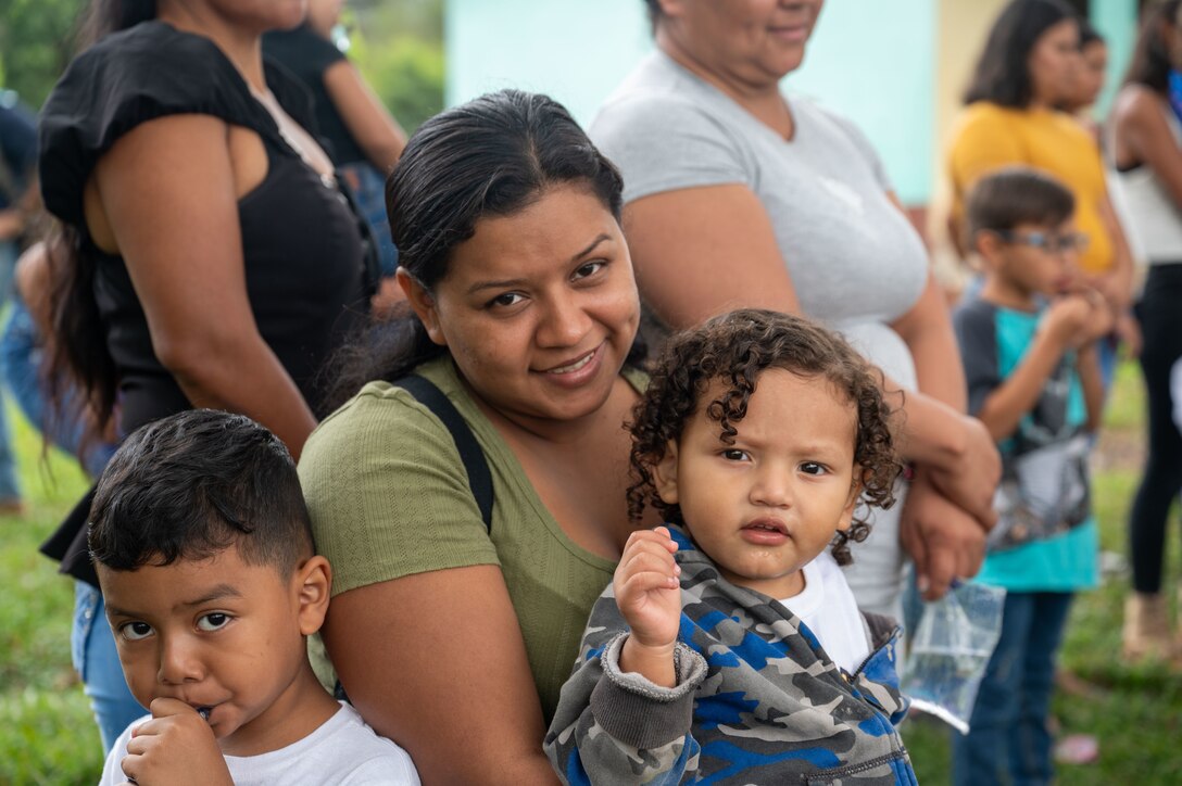 A mother and her young children wait to receive their food donation during Joint Task Force-Bravo’s 100th Chapel Hike Feb. 22 in El Llano de la Puerta, Comayagua, Honduras. The Chapel Hike, a volunteer program, has become synonymous with JTF-Bravo's commitment to the Honduran people. (U.S. Air Force photo by Capt. Hillary Gibson)