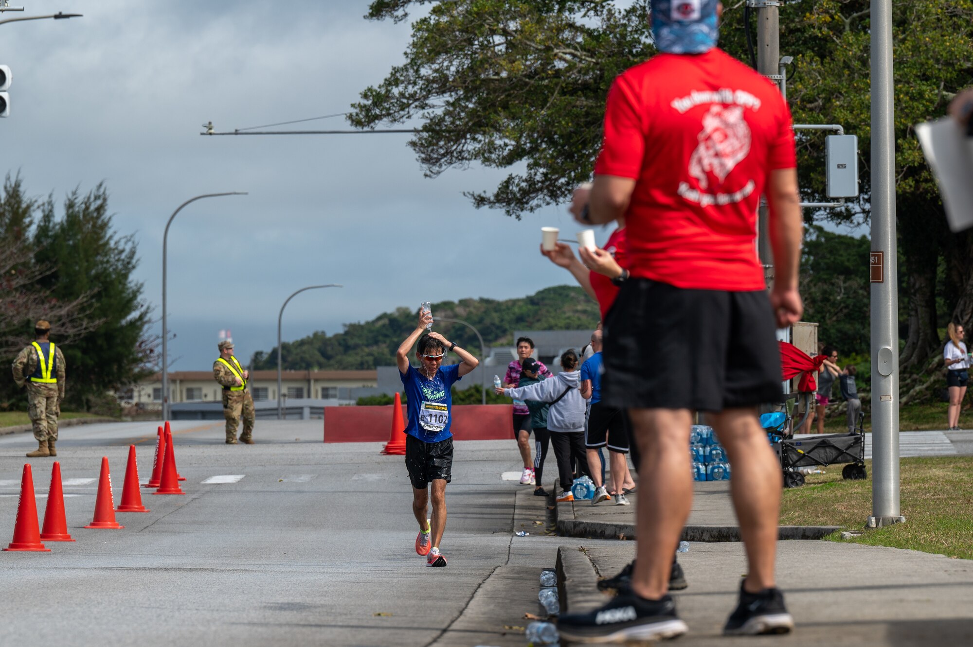 Runners take water from volunteers during the Okinawa Marathon