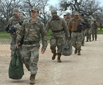 Event trainees proceed to the instruction facilities after retrieving their chemical, biological, radiological, nuclear, and explosive (CBRNE) protective equipment at Joint Base San Antonio-Lackland, Texas on Feb. 5, 2024. The value of the equipment lies squarely in its ability to protect the user from harm and aid in the detection, containment and decontamination of hazardous materials. (US Air Force photo by Alex Dieguez)