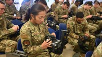 SrA Leslie Velasco configures the mask filter on a training mask during CBRN instruction at Joint Base San Antonio-Lackland, Texas on Feb. 5, 2024. Respirators must be properly sealed and fitted for effective use against airborne contaminants. (US Air Force photo by Alex Dieguez)
