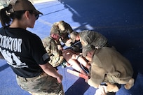 Event trainees are rated on their ability to conduct Tactical Combat Casualty Care (TCCC) at Joint Base San Antonio-Lackland, Texas on Feb. 7, 2024. The techniques are designed to reduce preventable trauma and death from combat injuries. In this scenario, a tourniquet has been applied to the training manikin to prevent mass blood loss and hemorrhaging while another member applies a large splint to its right leg. (US Air Force by Alex Dieguez)