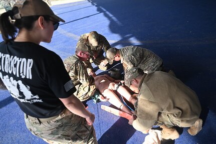 Event trainees are rated on their ability to conduct Tactical Combat Casualty Care (TCCC) at Joint Base San Antonio-Lackland, Texas on Feb. 7, 2024. The techniques are designed to reduce preventable trauma and death from combat injuries. In this scenario, a tourniquet has been applied to the training manikin to prevent mass blood loss and hemorrhaging while another member applies a large splint to its right leg. (US Air Force by Alex Dieguez)