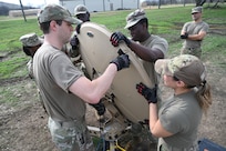 Members of the 960th Cyberspace Wing are instructed through the teardown of expeditionary communications (XCOMM) equipment at Joint Base San Antonio-Lackland, Texas on Feb. 8, 2024. The scale of the military satellite and associated components supports agile repositioning and rapid employment of C2 support. (US Air Force photo by Alex Dieguez)