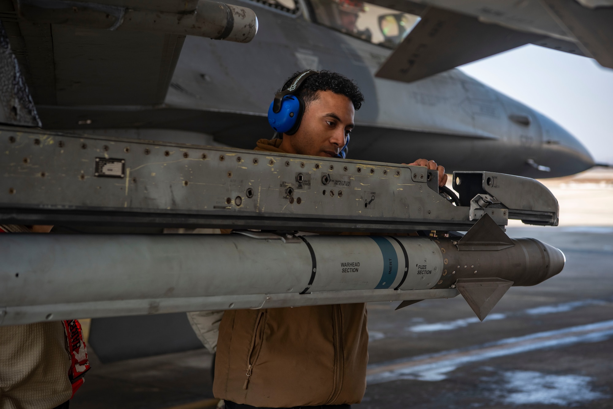 U.S. Air Force Staff Sgt. Malik Van Diver, 36th Fighter Generation Squadron weapons load crew chief, begins to remove an AIM-9X Sidewinder from an F-16 Fighting Falcon at Osan Air Base