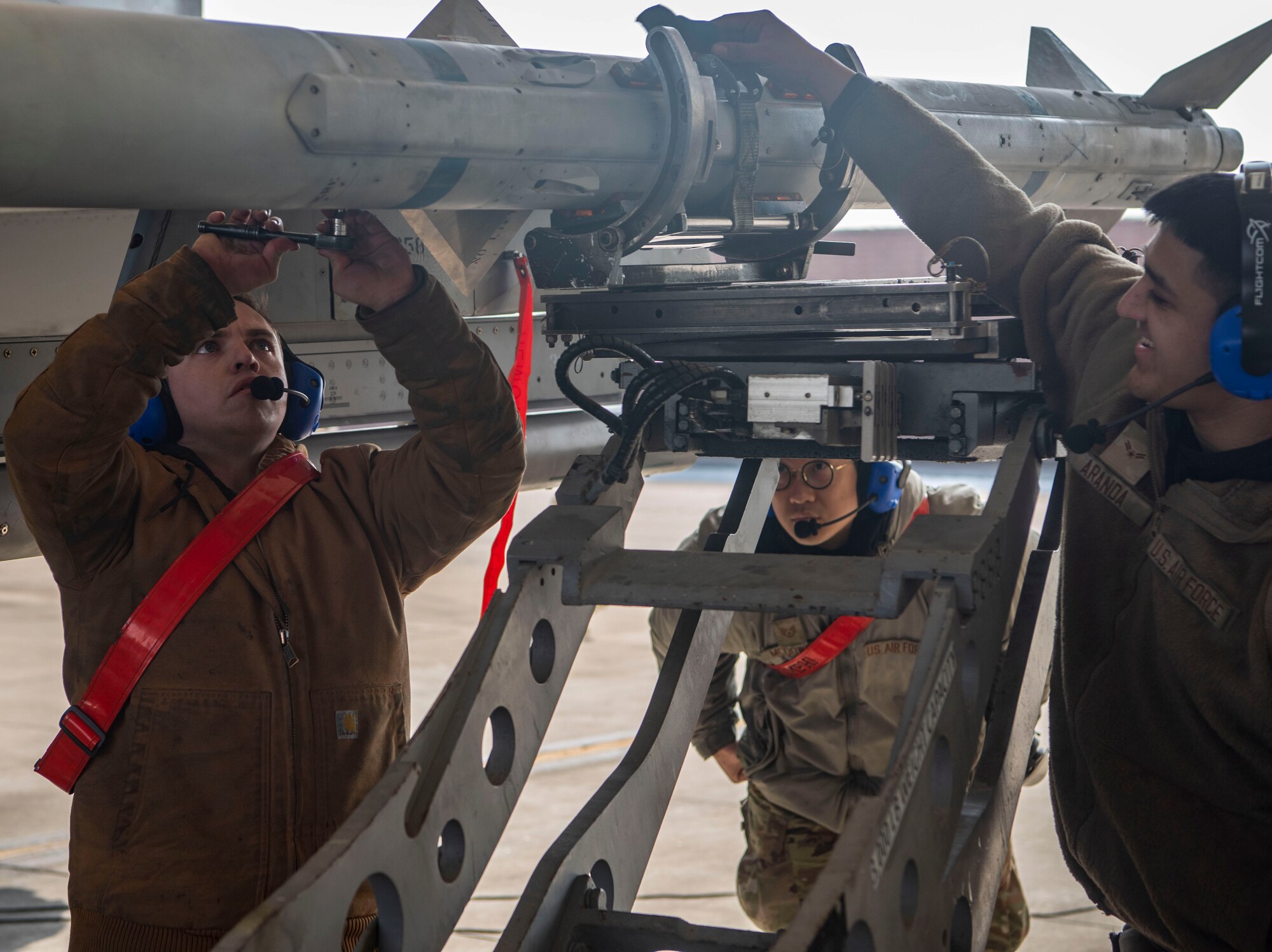 Airmen assigned to the 36th Fighter Generation Squadron mount an AIM-120 to an F-16 Fighting Falcon at Osan Air Base