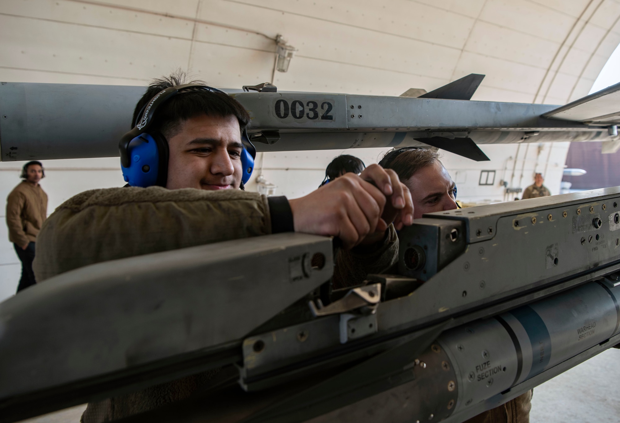 U.S. Air Force Airman 1st Class Patrick Aranda, 36th Fighter Generation Squadron weapons load crew member, left, Staff Sgt. Sydney Starkey, 36th FGS weapons load crew chief, secures an AIM-9X Sidewinder from an F-16 Fighting Falcon at Osan Air Base