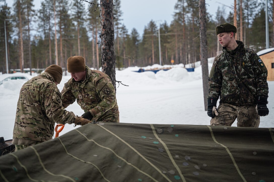 Soldiers set up a Finnish tent