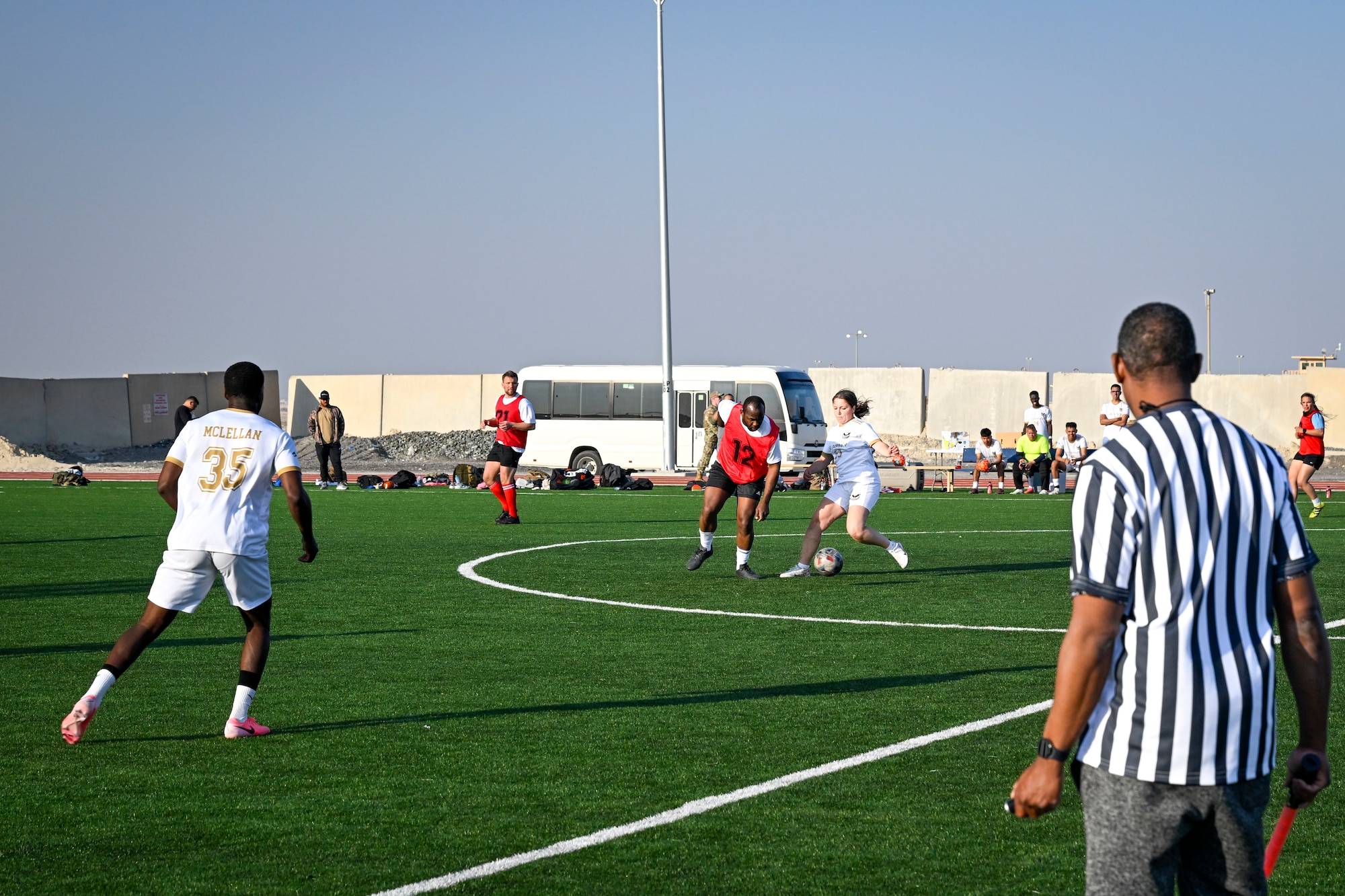 A group of people play soccer.