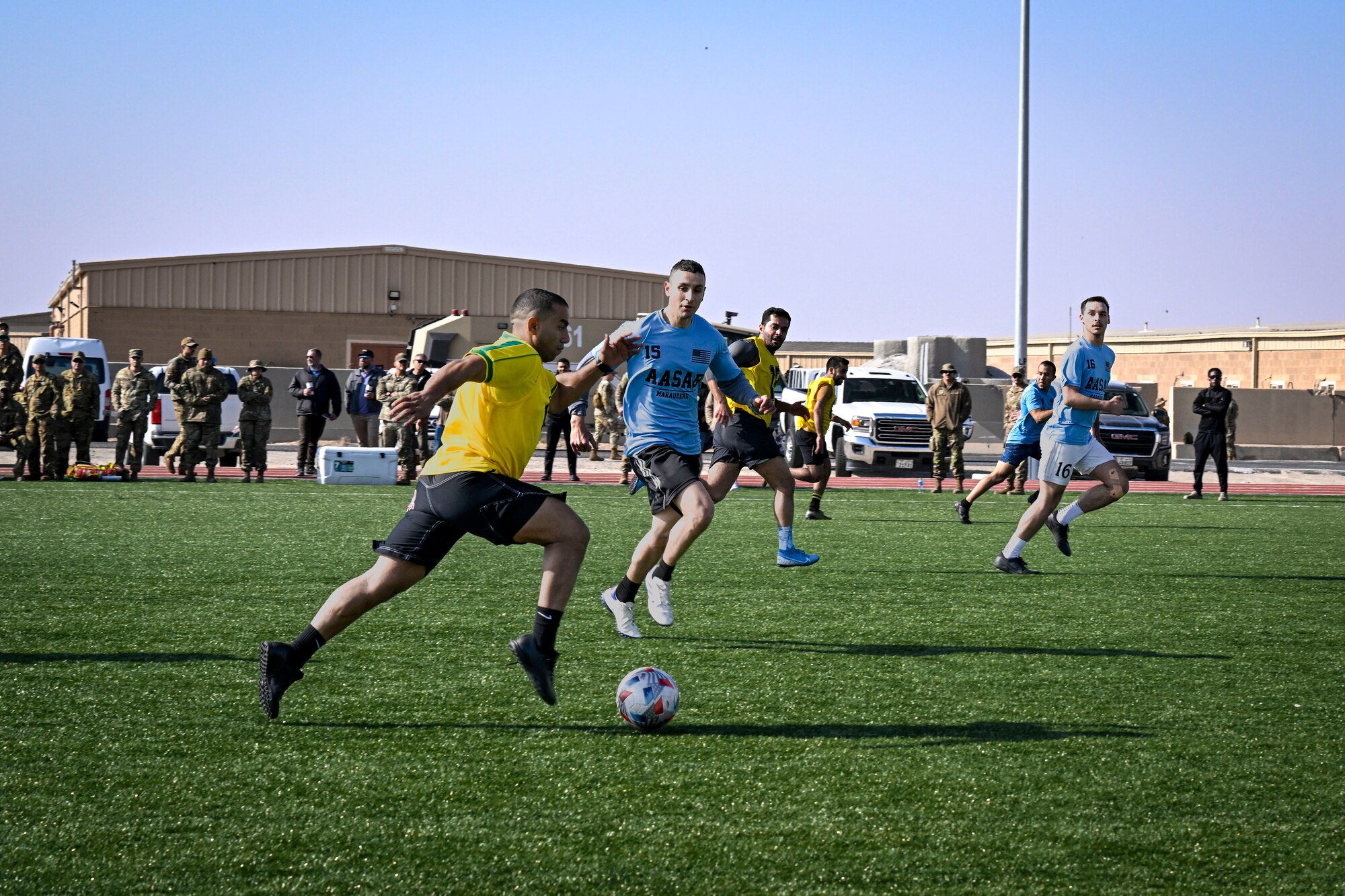 A group of men play soccer.