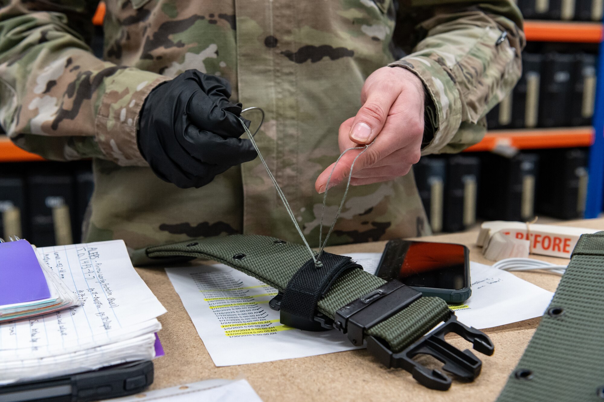 U.S. Air Force Senior Airman Carlos Frias, 100th Operations Support Squadron aircrew flight equipment technician, works on a belt to ensure the loop stays in place at RAF Mildenhall, England, Feb. 6, 2025.