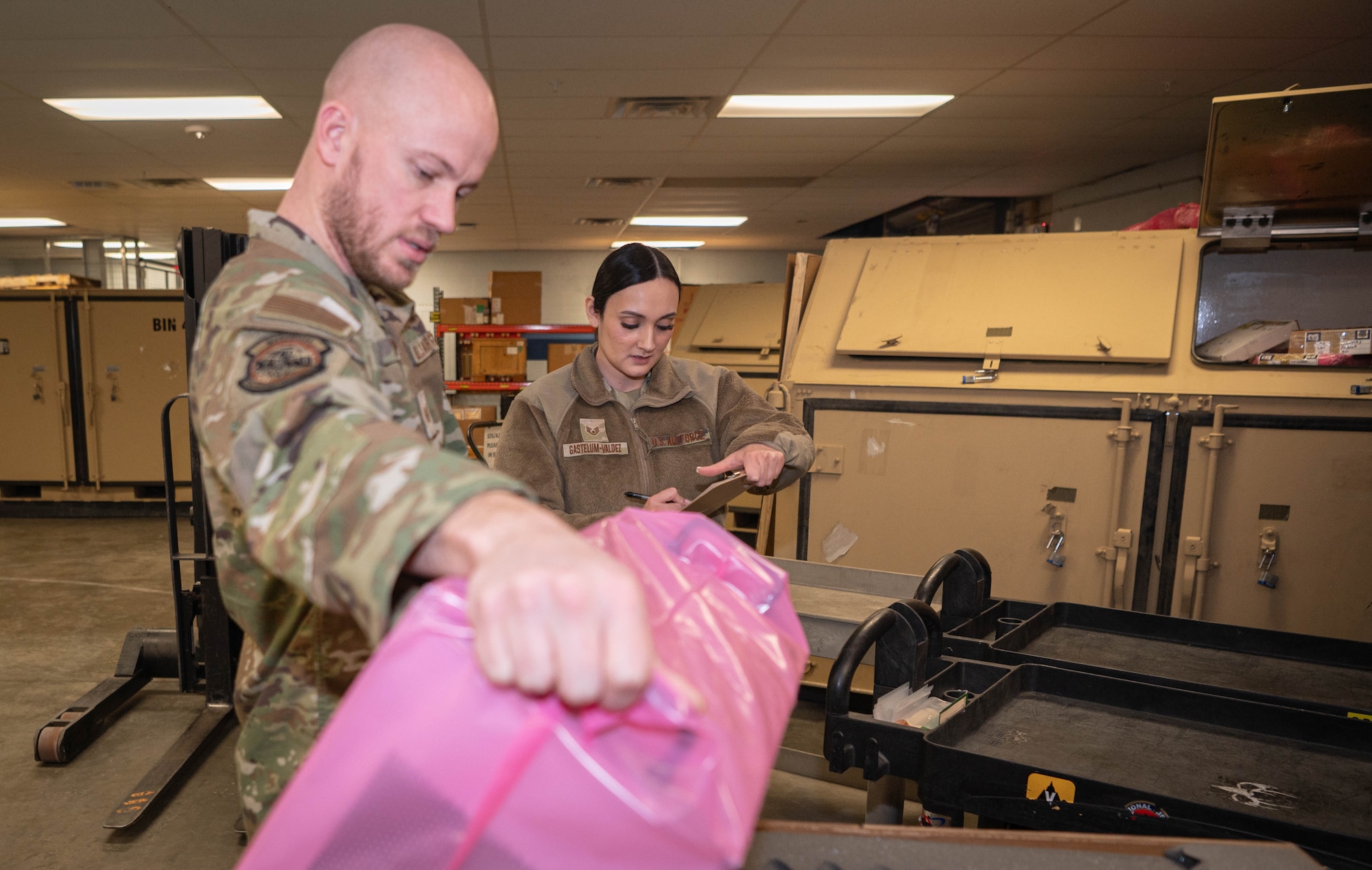 Tech. Sgt. Tyler Powers, 55th Logistics Readiness Squadron NCO-in-charge of special depot support, and Staff Sgt. Arianna Gastelum-Valdez, 55th LRS special depot support supervisor, prepare boxes for palletizing as part of an air cargo shipment at the Bennie Davis facility Feb. 20, 2025.