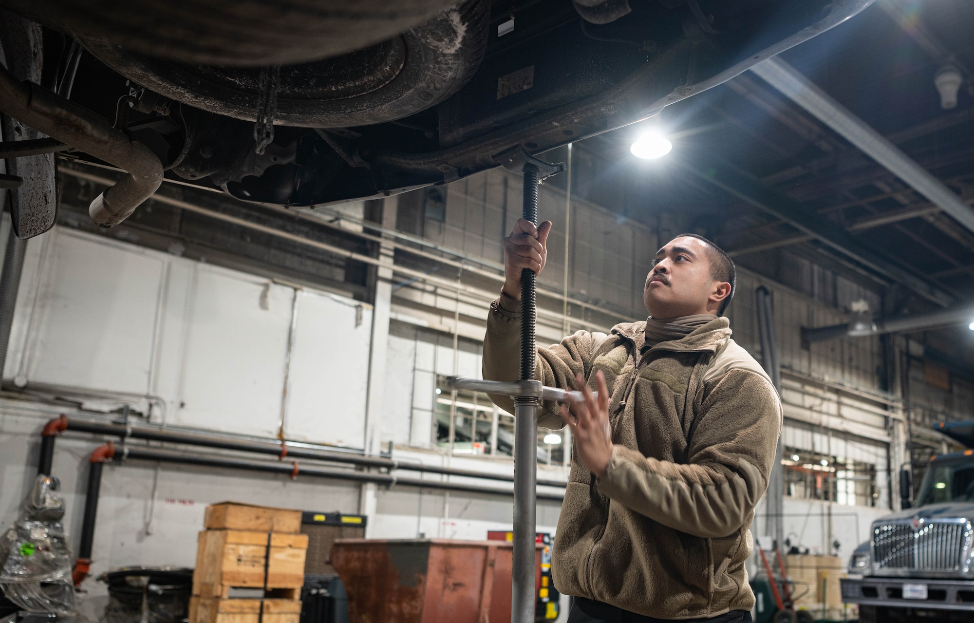 Staff Sgt. Gerardo Tomas, 55th Logistics Readiness Squadron NCO-in-charge of the vehicle maintenance customer service center, secures a vehicle in place after propping it up with a hydraulic lift in preparation for maintenance in Building D Feb. 21, 2025.
