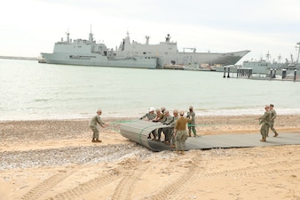 Seabees from NMCB-1 set up an expeditionary site stability system during an operational assessment of port damage repair operations at Naval Station Rota.