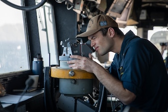 A U.S. Navy officer looks through an alidade on the bridge aboard USS Gettysburg (CG 64) as the ship transits the U.S. Central Command area of responsibility.