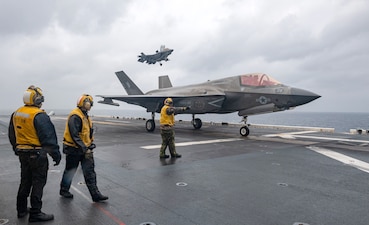 Sailors aboard USS America (LHA 6) guide an F-35B Lightning II fighter aircraft from VMFA-242 during flight operations in the Philippine Sea.