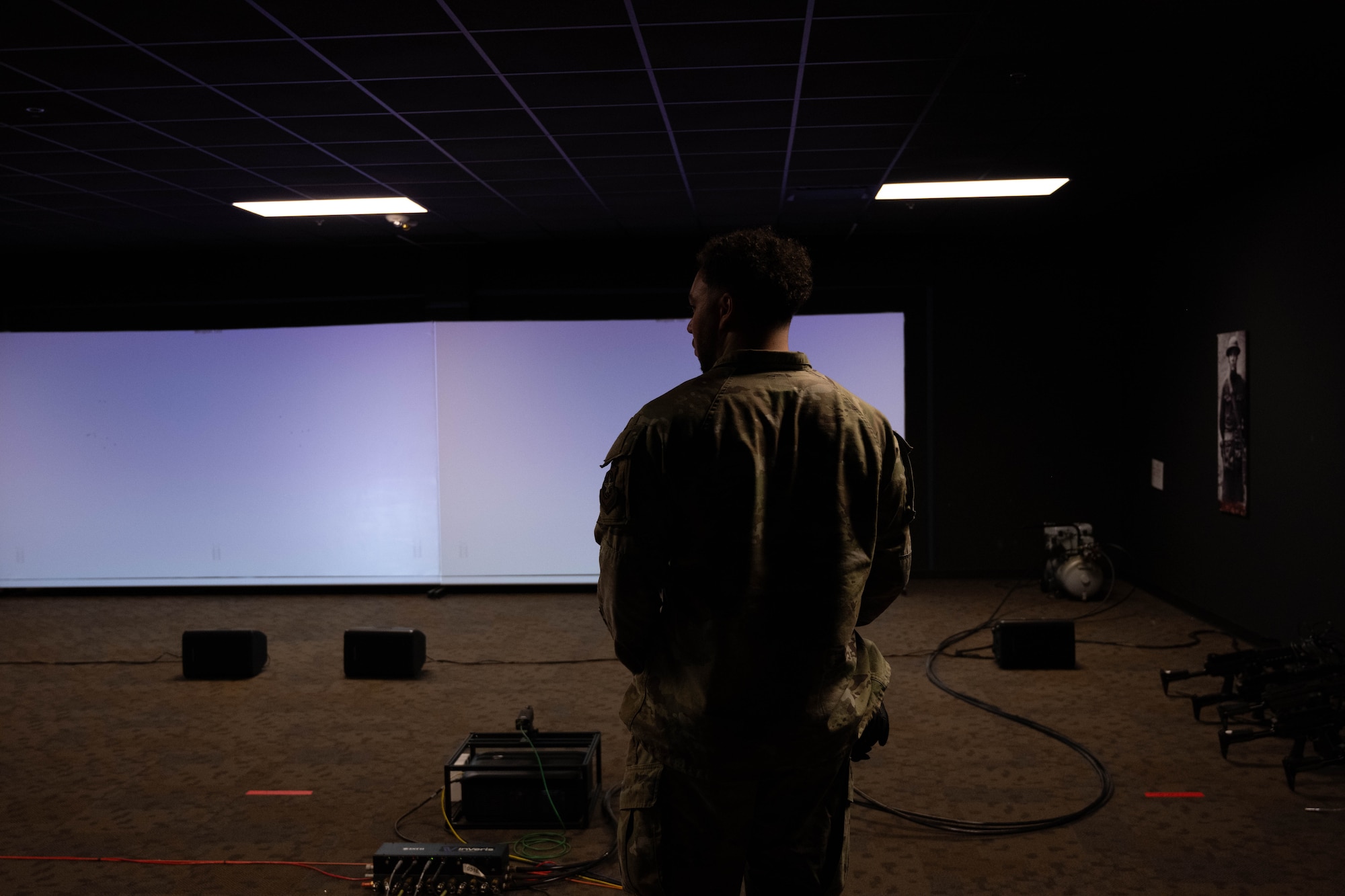 A U.S Airman stands waiting for weapons training simulator to start.
