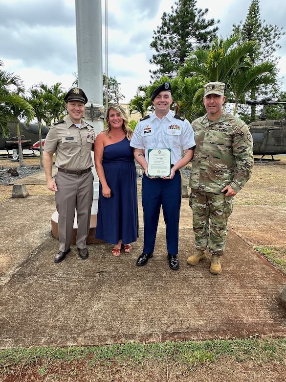 U.S. Army Colonel, U.S. Army Command Sergeant Major, U.S. Army Staff Sergeant, civilian pose together after promotion ceremony.