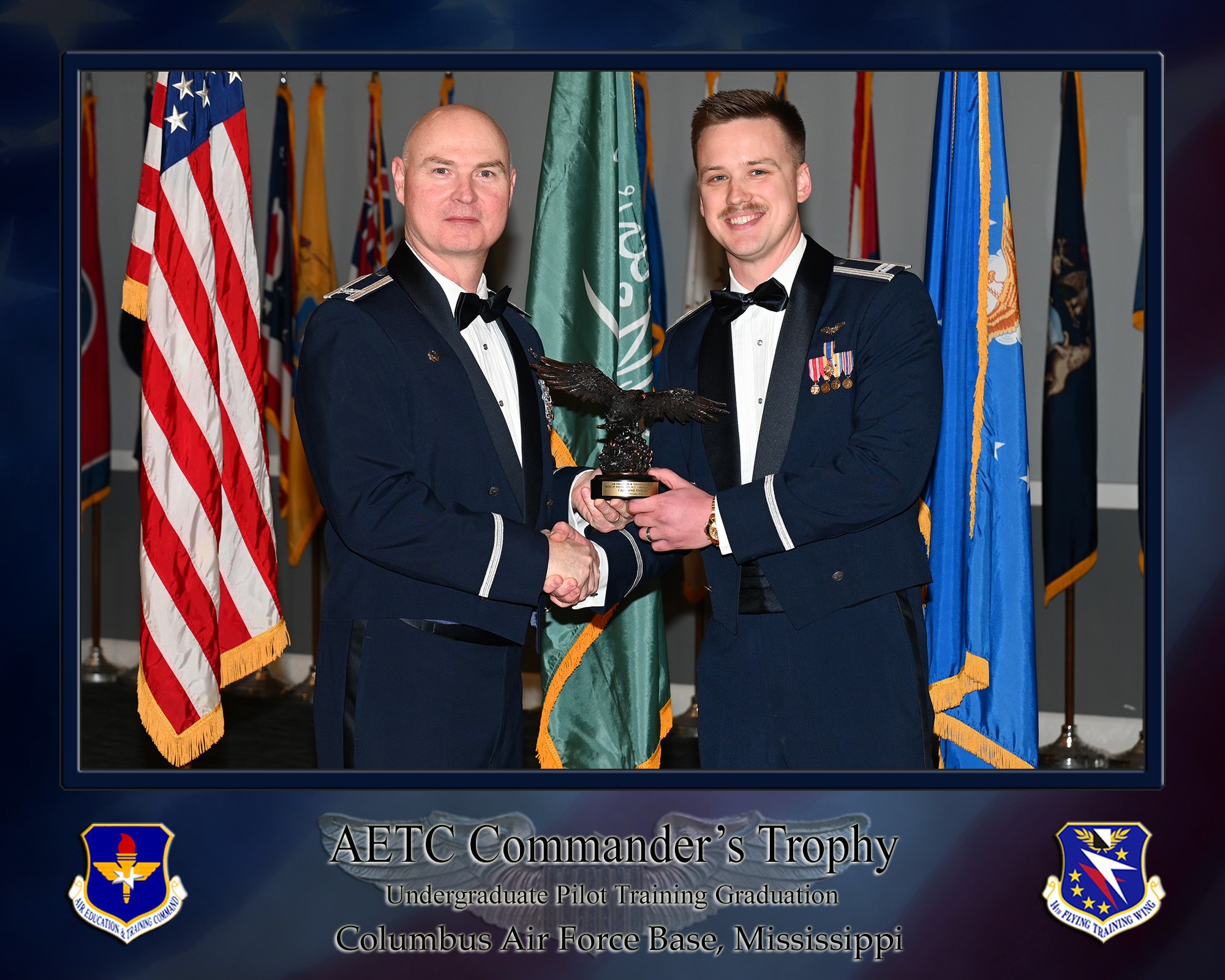 Undergraduate Pilot Training Class 25-05 graduation speaker Col. Jason R. Herring and Capt Jared L. Holsclaw, pose for a photo with the Air Education and Training Command commander’s trophy during the official graduation ceremony on February 14, 2024, at the Columbus Events Center on Columbus Air Force Base, Mississippi.