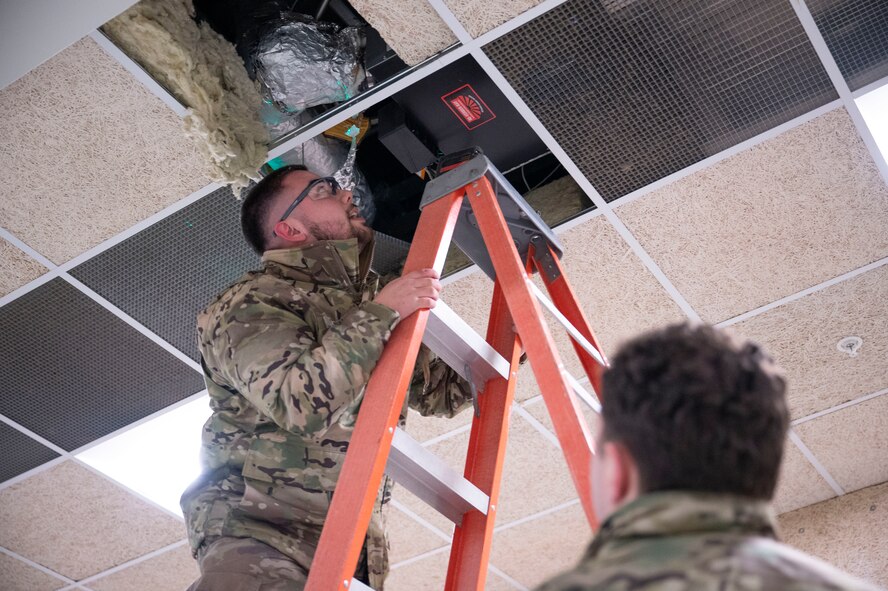 Senior Airman Kyle Corcoran, a heating, ventilation, air conditioning and refrigeration specialist assigned to the 5th Civil Engineer Squadron, inspects an infrared heater at the Combat Arms Training and Maintenance building on Minot Air Force Base, North Dakota, Feb. 18, 2025. Functional airflow is important in the CATM range because downrange airflow prevents firearm debris from blowing back toward Airmen. (U.S. Air Force photo by Senior Airman Kendra A. Ransum)
